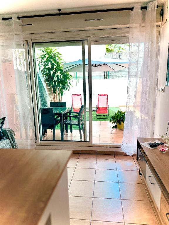 a kitchen with sliding glass doors leading to a patio at Le Petit Oasis à Saint-Denis in Saint-Denis