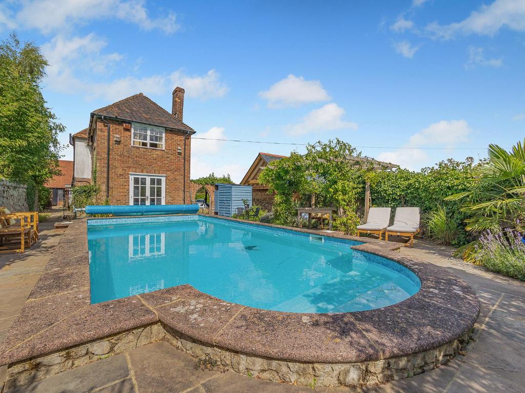 a swimming pool in front of a house at Dunnock - Uk50146 in Faversham