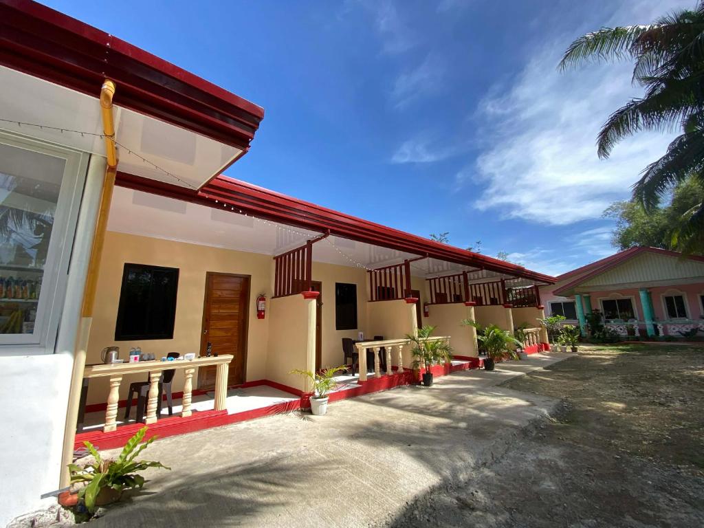 a building with a row of tables and benches at JEHH8 Guest House in Siquijor