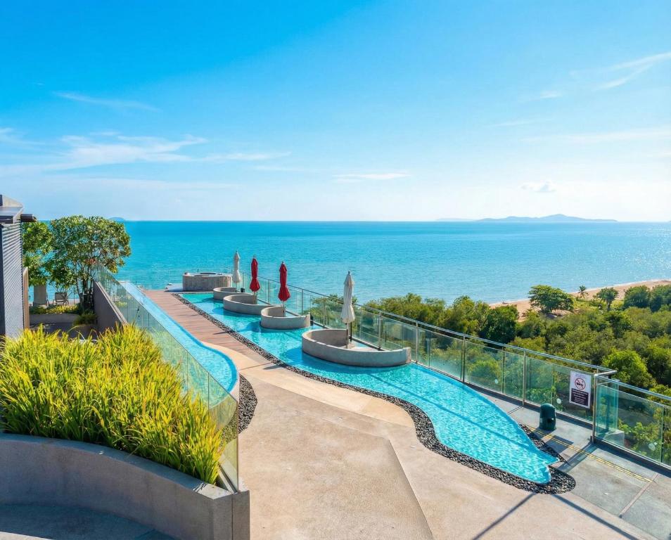 a swimming pool with a view of the ocean at Bayphere Residence by Prop Hopper in Na Jomtien