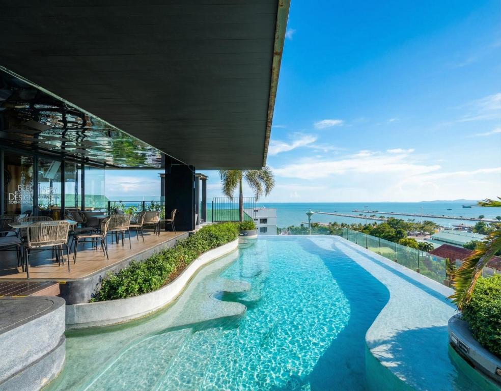 an infinity pool in a house with a view of the ocean at Seaphere Residence by Prop Hopper in Na Jomtien