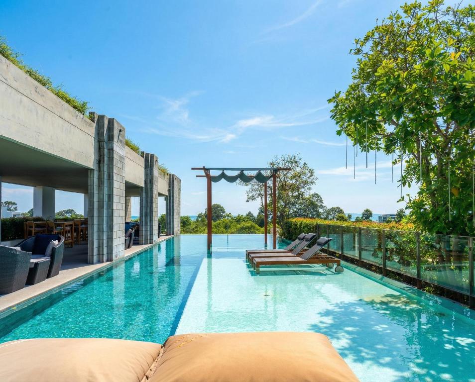 a swimming pool with two chaise lounges on the side at Oceanphere Villa by Prop Hopper in Bang Sare