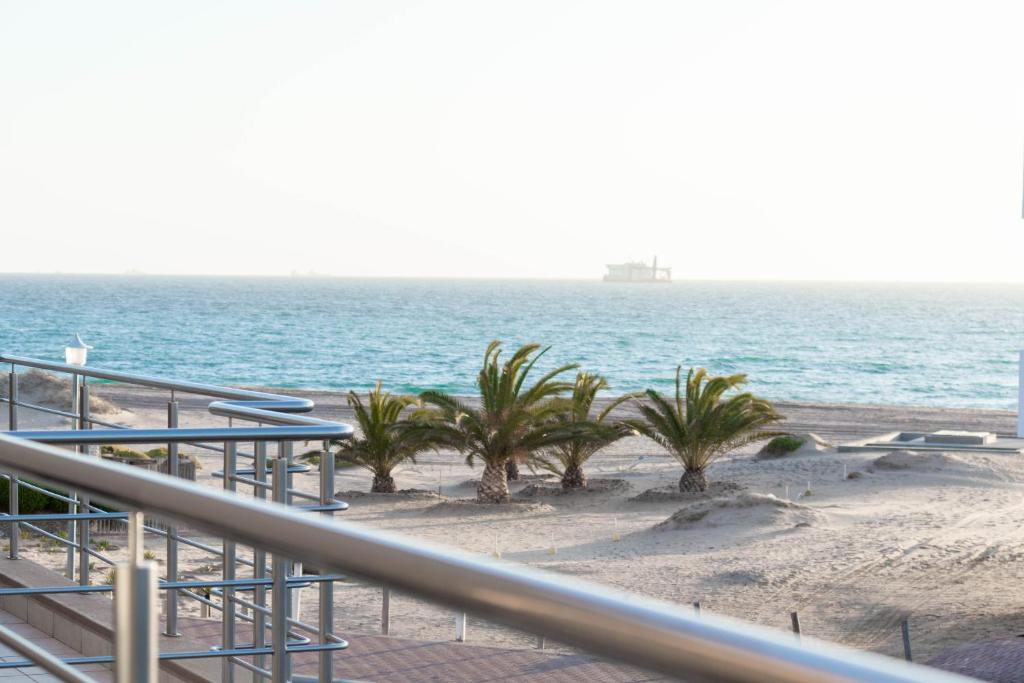 a view of the beach with palm trees and the ocean at Don Self Catering in Walvis Bay