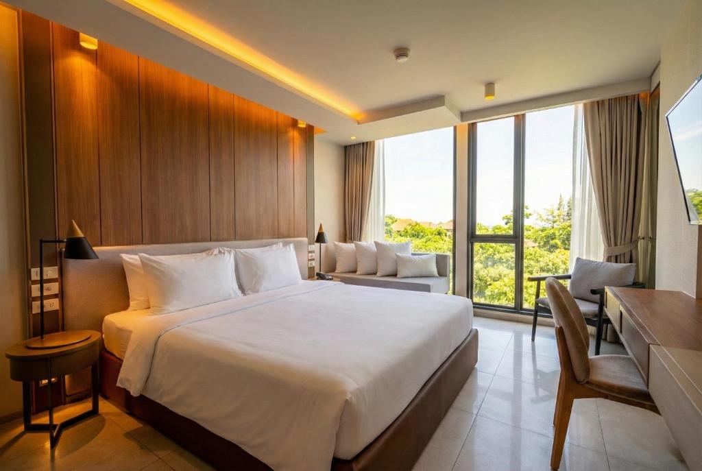 a hotel room with a large bed and a couch at Bluphere Residence by Prop Hopper in Na Jomtien