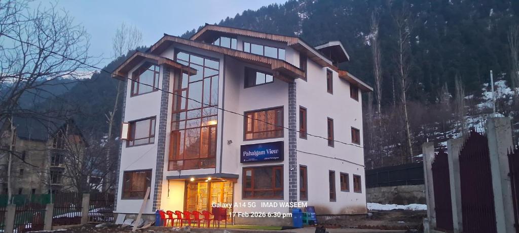 a large white building with windows on a mountain at Hotel Pahalgam view in Pahalgām