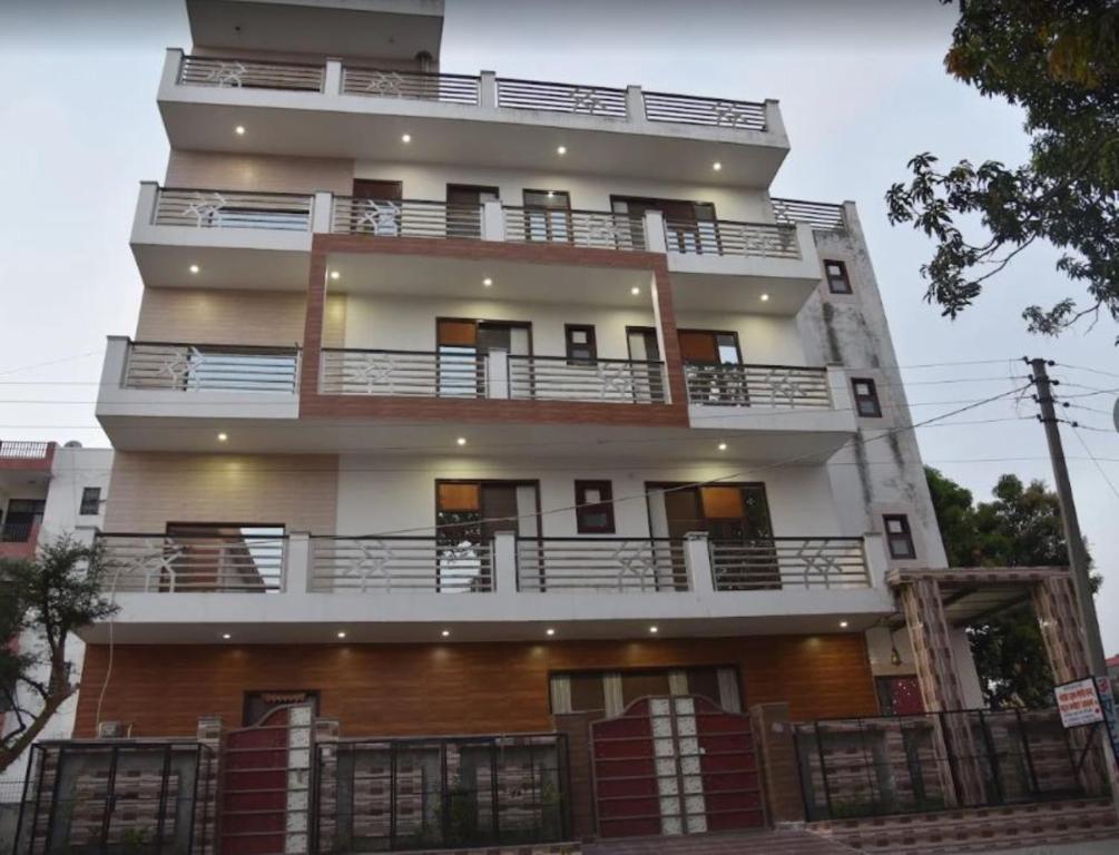 a tall white building with balconies on it at The Gopi Dham Hotel in Haridwār
