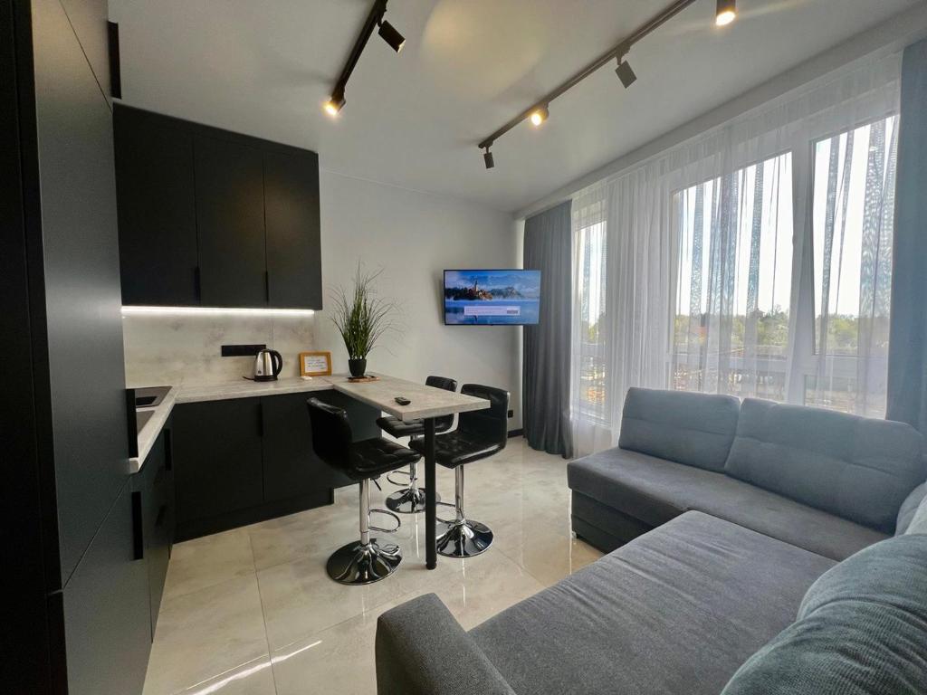a kitchen and living room with a couch and a table at Апартаменти Парус Сіті in Lviv