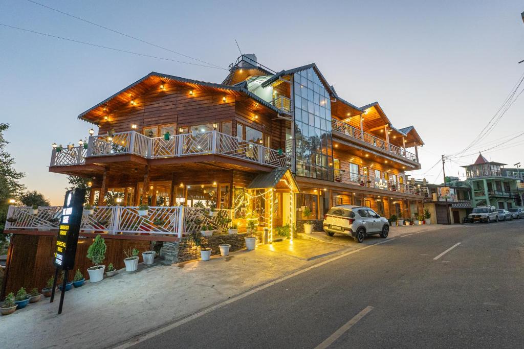 a wooden house with a car parked in front of it at The Golden Castle Hotels in Mukteshwar