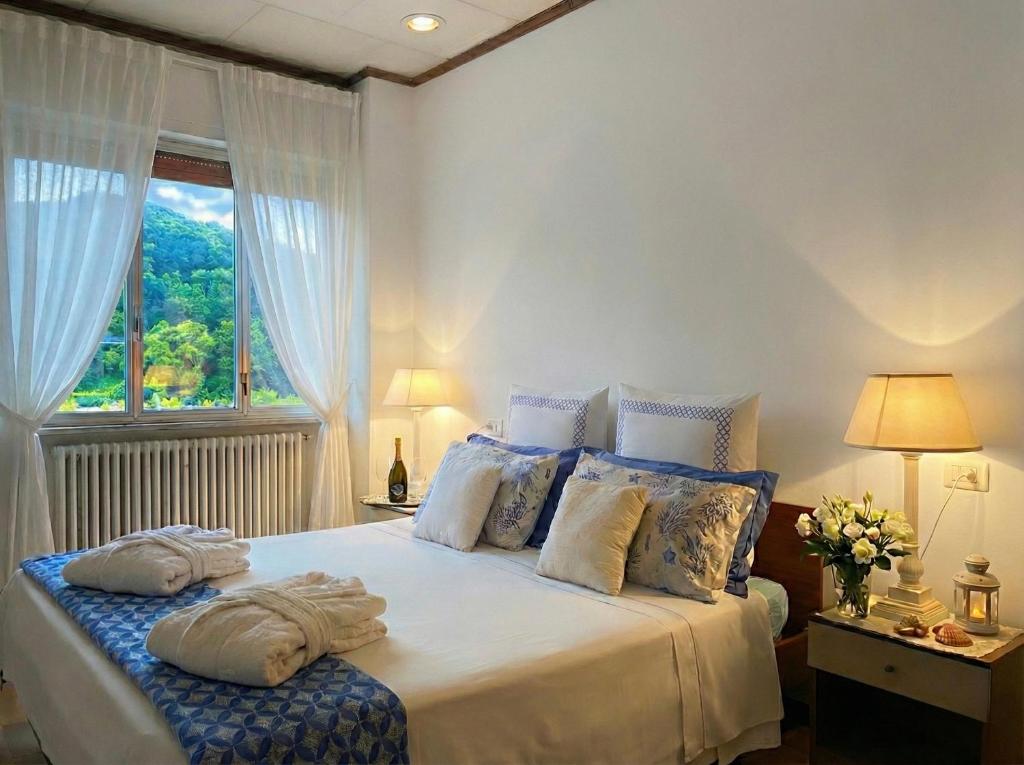 a bedroom with a bed with pillows and a window at Lunigiana e Mare in Aulla