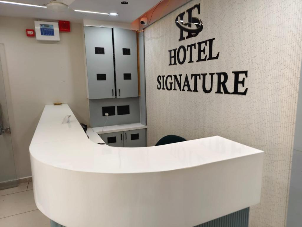 a hotel signature sign on a wall in a room at Hotel Signature Bopal in Ahmedabad