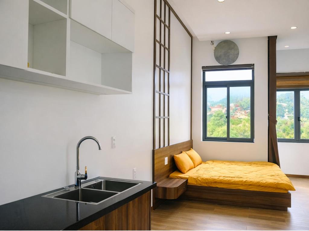 a kitchen with a sink and a bed in a room at B'lao Eco Lodge in Bảo Lộc