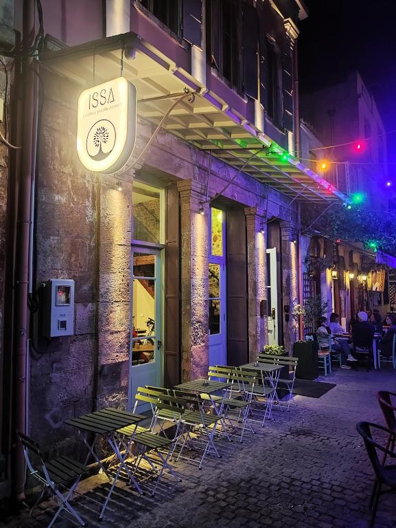 a group of tables and chairs on a street at night at ISSA Lesvos in Mytilene