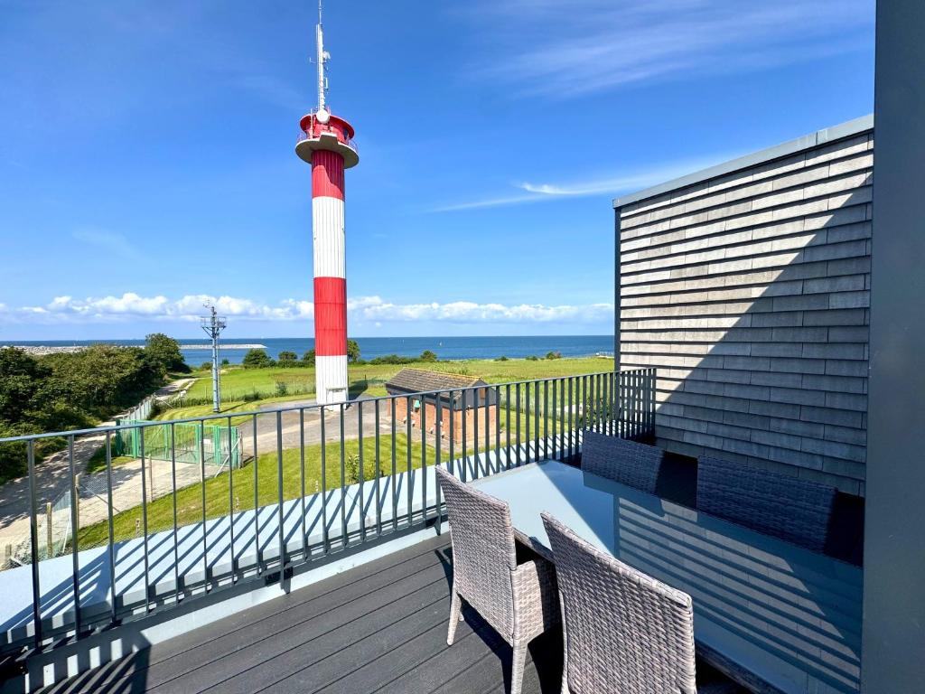 a balcony with two chairs and a lighthouse at Penthouse Seeblick am Leuchtturm in Fehmarn