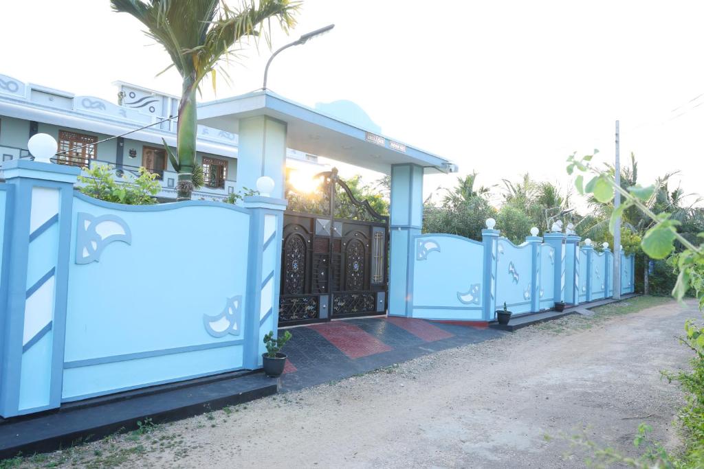a row of blue gates in front of a house at Annai Agham in Kankesanturai