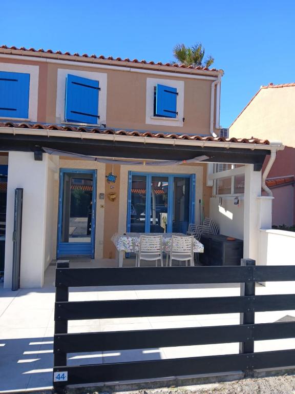 a house with a table and chairs on the porch at Maisonnette n 43" La Tortue " in Frontignan
