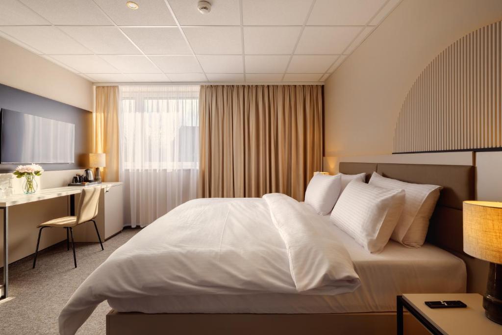 a hotel room with a bed and a desk at Yuko Residence in Jasło