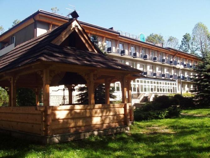 a wooden gazebo in front of a building at OW Jaskółka in Zakopane