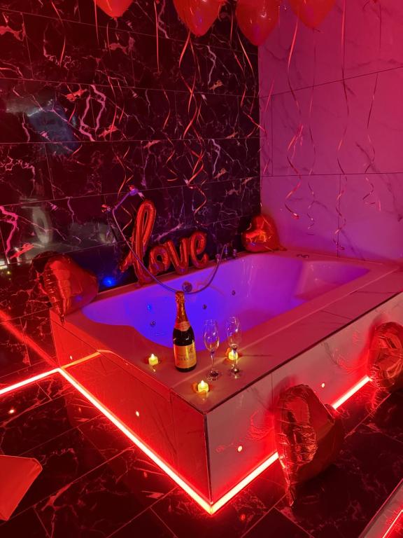 a room with a tub with a bottle of wine at Luxury Jacuzzi Suites Halifax in Halifax