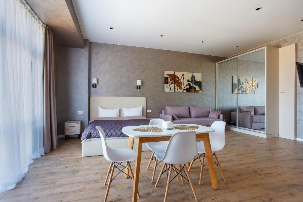a bedroom with a bed and a table and chairs at Five seasons Family in Odesa