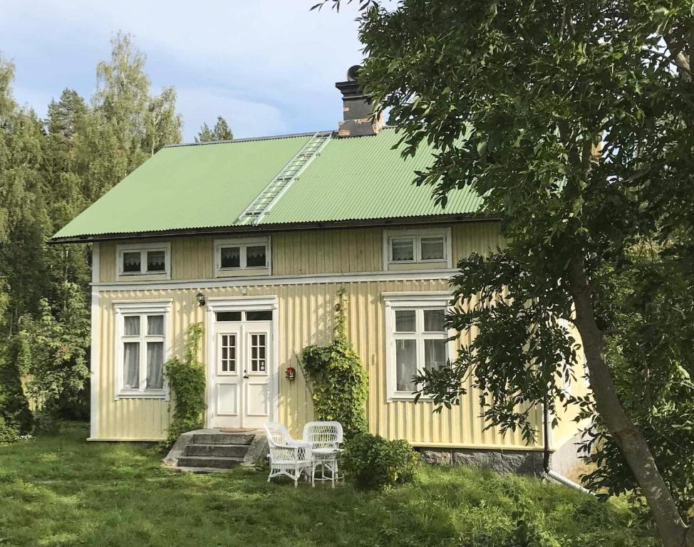 a yellow house with a green roof at Lakeside Guesthouse, Lillstugan in Ramvik