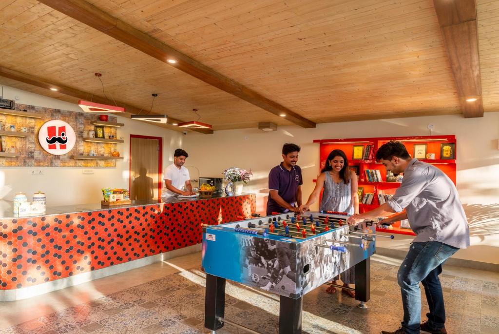 a group of people standing around a table playing chess at Moustache Hostel Nainital in Nainital