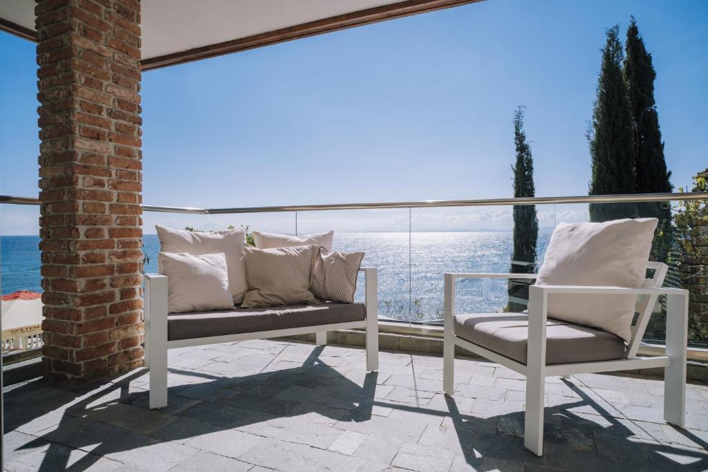 a patio with two chairs and a view of the ocean at Villa Alenor – Sea View & Beach Access in Nesebar