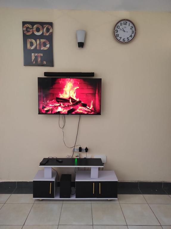 a tv on a wall with a fire on it at GCG STAYS ltd in Mtwapa