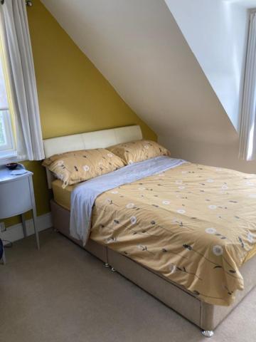 a small bed in a room with a yellow wall at House on the Corner B&B in Didcot