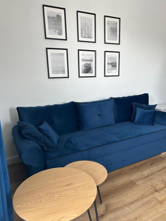 a living room with a blue couch and a table at Apartament Parkowa-prywatny parking in Olecko
