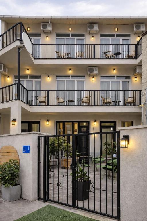 an apartment building with a balcony with tables and chairs at Hotel Marioni in Tbilisi City
