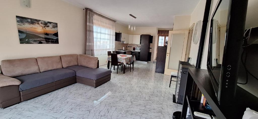 a living room with a couch and a kitchen at Mara casa vacanza in Maracalagonis
