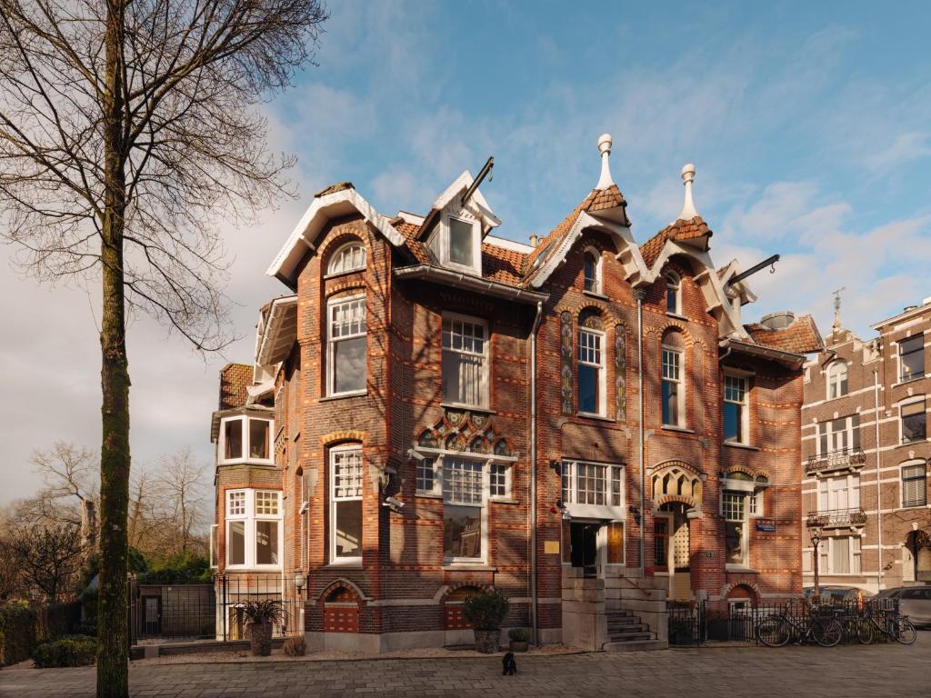 a large red brick building with a roof at Adam's Museum House in Amsterdam