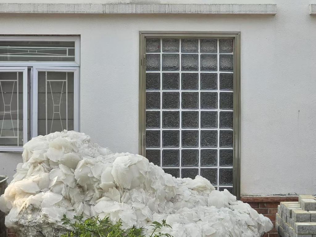 a large pile of snow in front of a house at Farm Cottage in Hong Kong