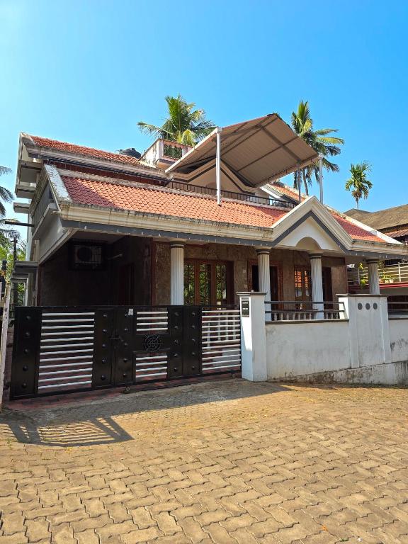 a house with a gate in front of it at Spacious 2 Bedroom Private House in Mangalore Fully Air-Conditioned, WiFi & Parking in Mangalore