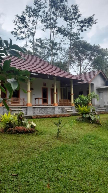 a small house with a grass yard in front of it at Bali Home Taksu in Jatiluwih