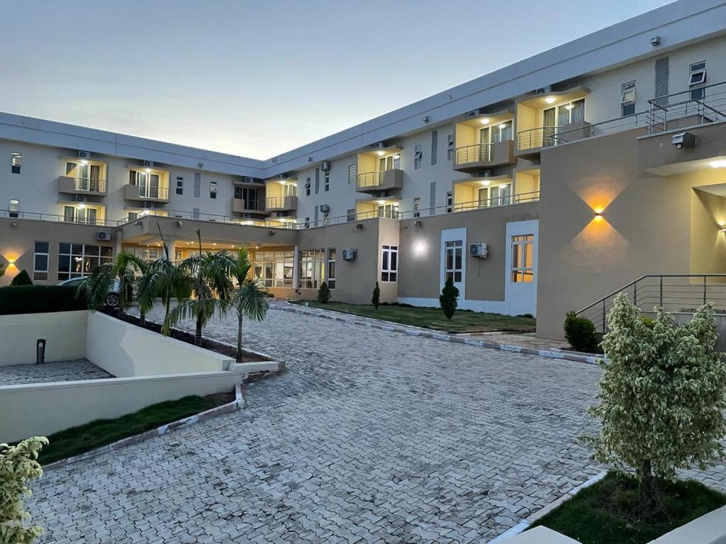 an empty courtyard of a building with palm trees at Golden Alpine Hotel in Yola