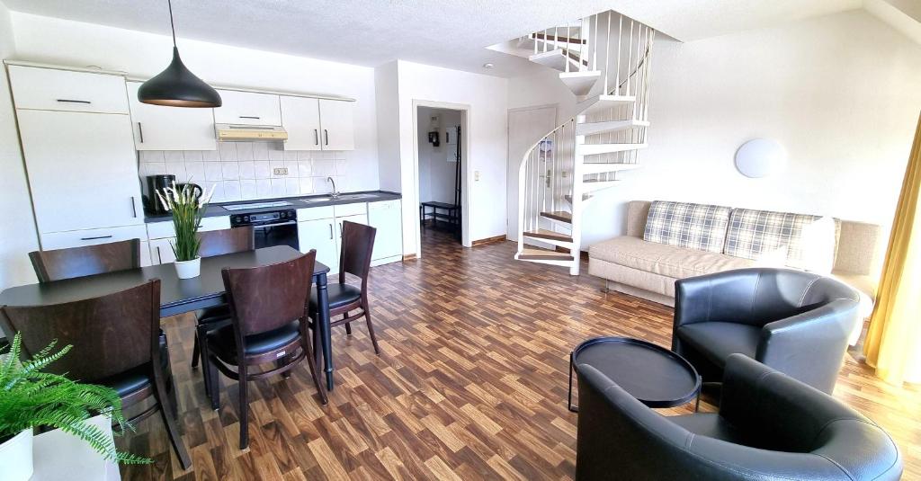 a kitchen and living room with a table and chairs at Boddenhof Apartment 56 - 2 SZ, freundlich, modern in Buschvitz