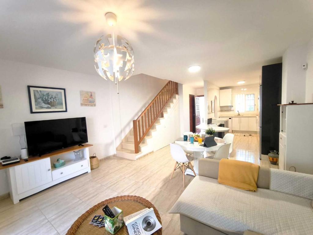 a living room with a couch and a tv at RenTenerife EspebelBeach in El Médano