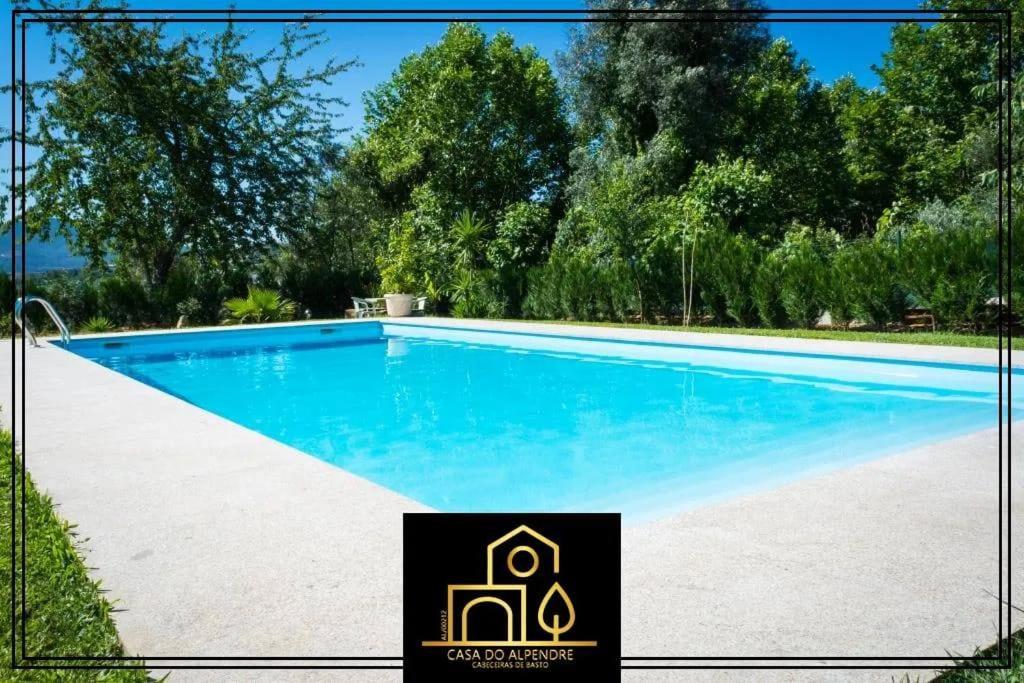 a swimming pool with a sign in front of it at Casa do Alpendre in Arco de Baúlhe