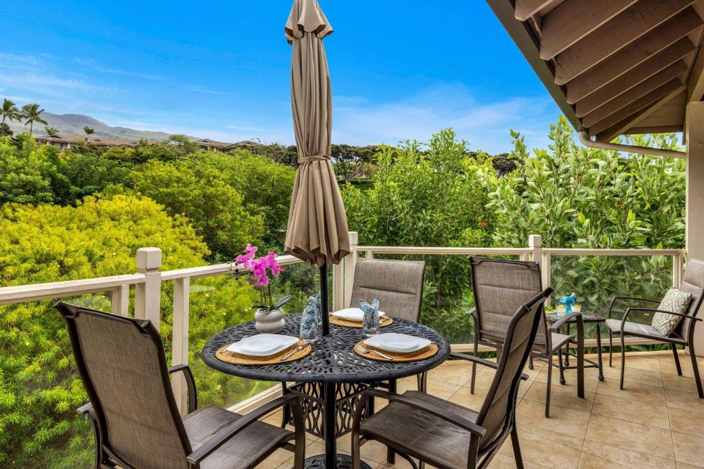 a patio with a table and chairs and an umbrella at Grand Champions 124 · GC 124 3BD Wailea Condo wAC Pool Hot Tub in Wailea