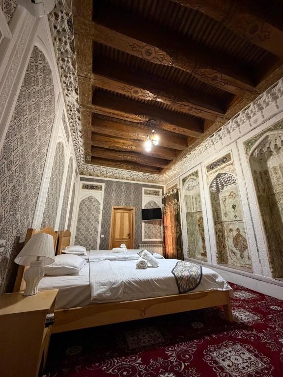 a bedroom with a large bed in a room with wallpaper at Boutique ALISHER in Bukhara