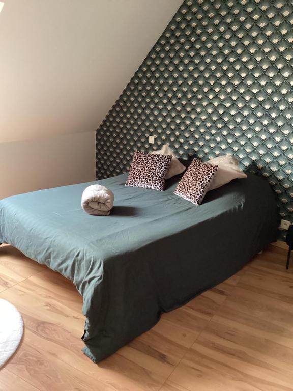 a bedroom with a bed with a headboard and pillows at Chez Nathou in Janzé