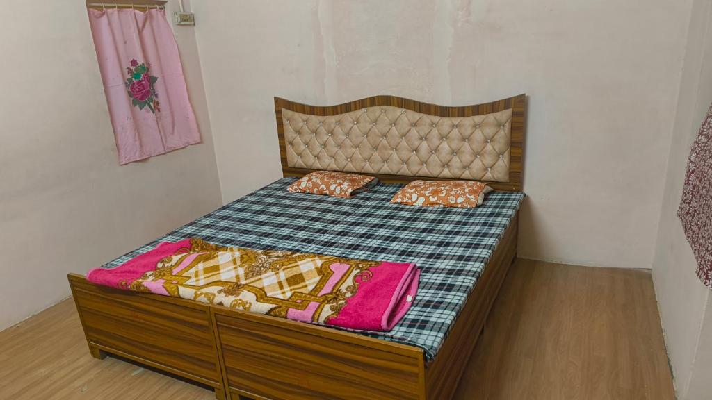 a bed with two pillows on it in a room at Arihant Guest House in Ujjain