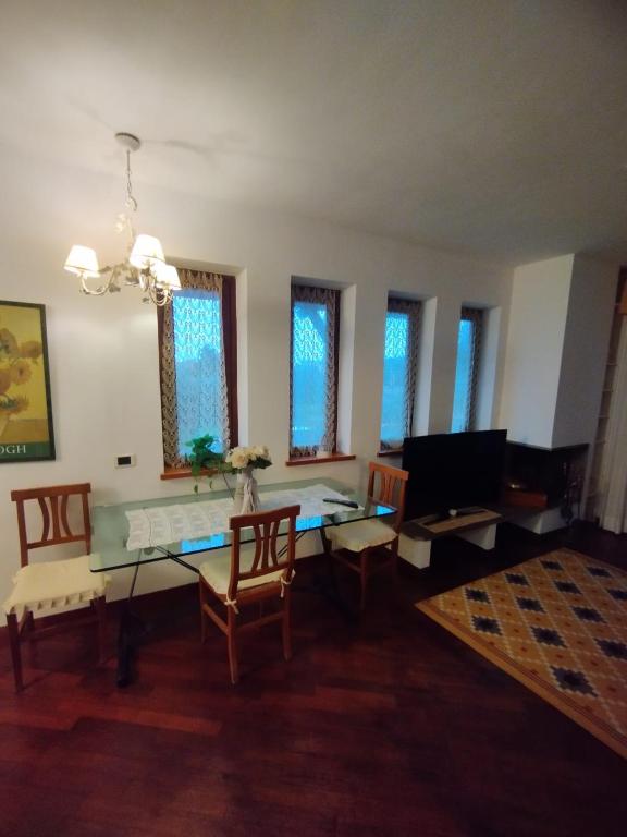 a living room with a table and chairs and windows at La Terrazza dei Fiori Roma Home Sweet Home Viterbo in Cesano