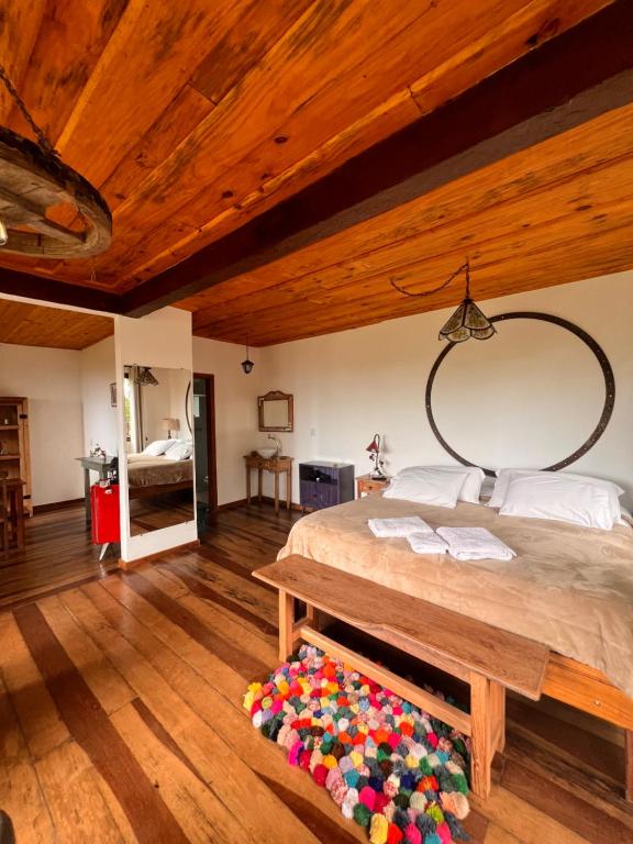 a bedroom with a large bed with a wooden ceiling at Chalé da Mata Lavras Novas in Lavras Novas