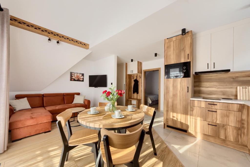 a kitchen and living room with a table and chairs at Pokoje KAMILA - Apartament 5 min pieszo do Kotelnicy in Białka Tatrzańska
