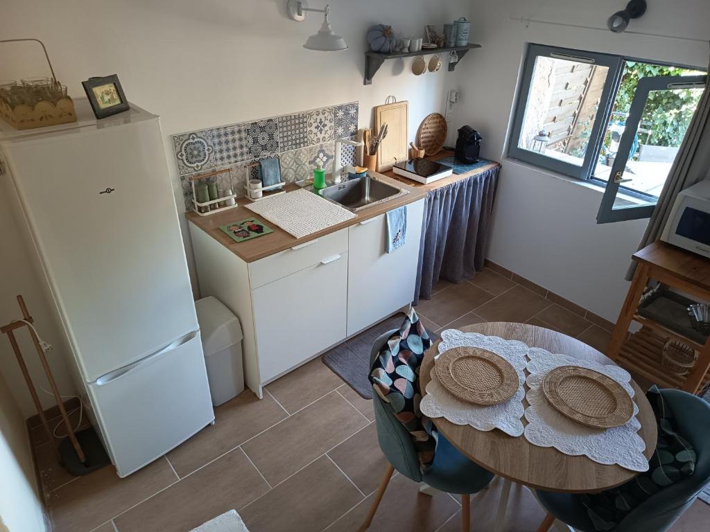 a small kitchen with a table and a refrigerator at Le refuge de Teddy in Solliès-Toucas