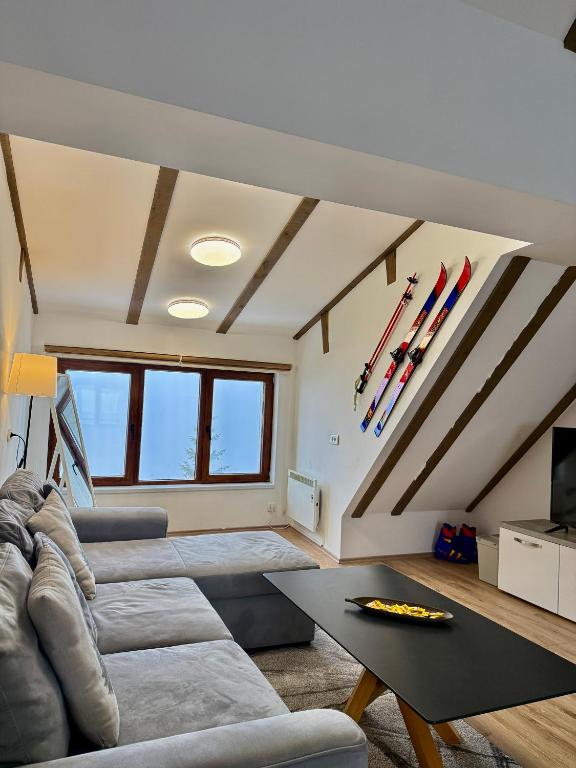 a living room with a couch and a table at The Pine Loft by Kopaonik in Kopaonik