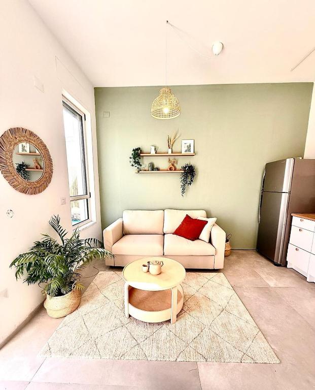 a living room with a couch and a table at Flamingo Suite in Atlit