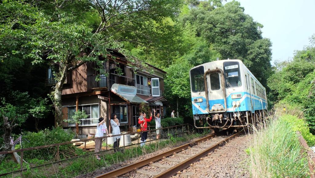 a train on the tracks next to a house at Kappa Backpackers in Shimanto-cho